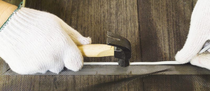 Man is working with mosquito wire screen installation